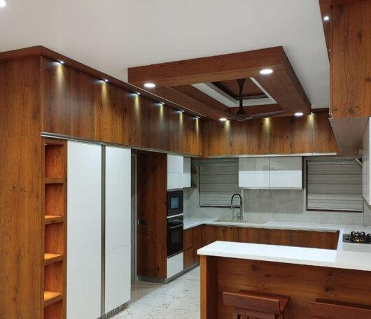 contemporary-wood-finish-kitchen-with-breakfast-counter-parkland-thrissur-kerala