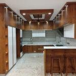 Contemporary wood finish kitchen with breakfast counter parkland thrissur kerala