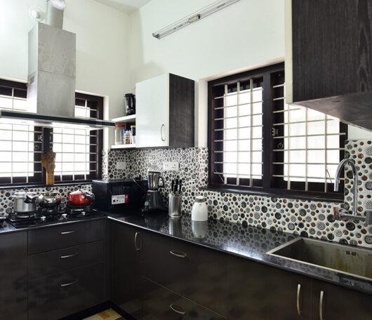 sleek-dark-wood-kitchen-with-pattern-tiles-parkland-thrissur-kerala