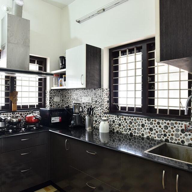 sleek-dark-wood-kitchen-with-pattern-tiles-parkland-thrissur-kerala