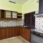 Wood finish kitchen with pattern tiles parkland thrissur kerala